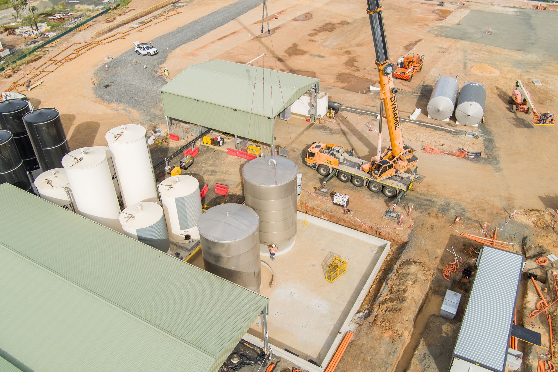 Aerial view of a construction site with tanks, a crane, and buildings — Dynamic Crane Hire In Emerald, QLD