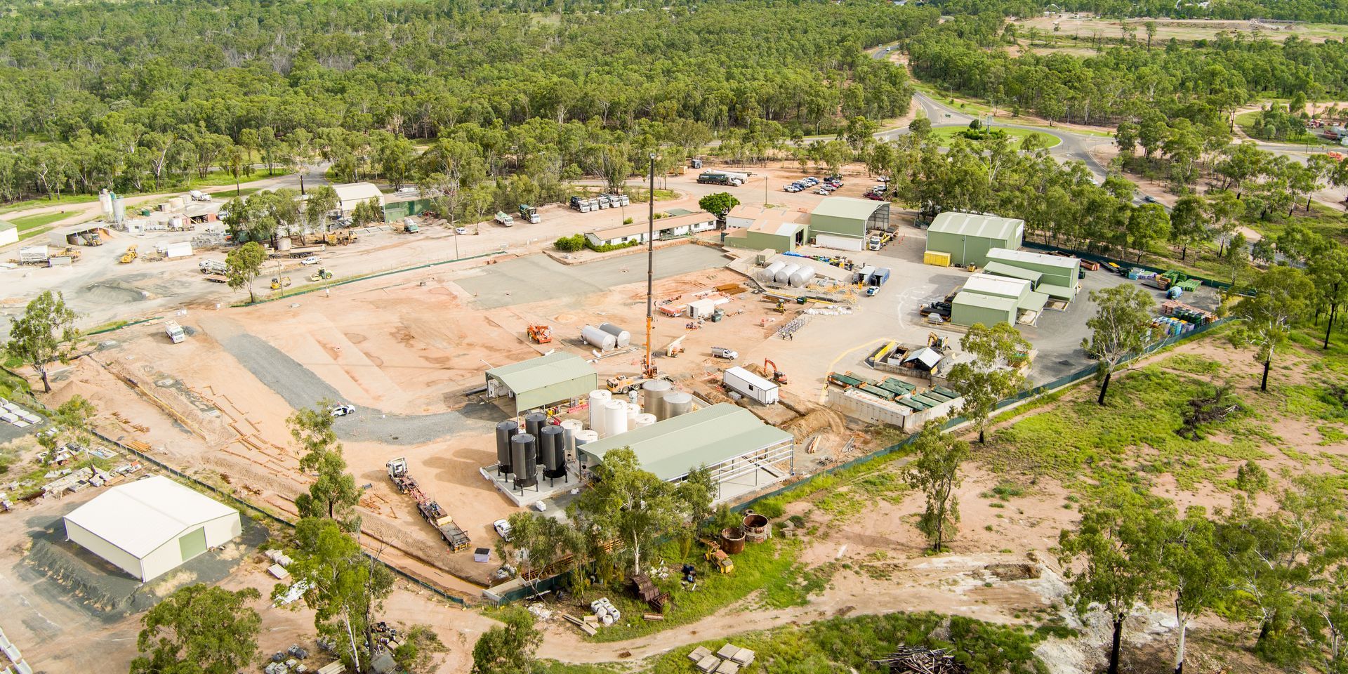 Aerial view of a construction site surrounded by trees, with buildings and equipment — Dynamic Crane Hire In Emerald, QLD