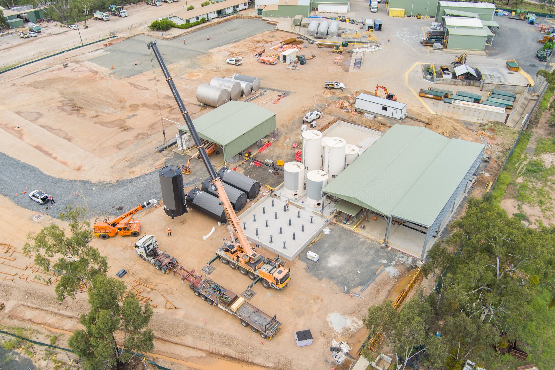 Aerial view of a construction site with cranes, buildings, tanks, and trucks — Dynamic Crane Hire In Emerald, QLD