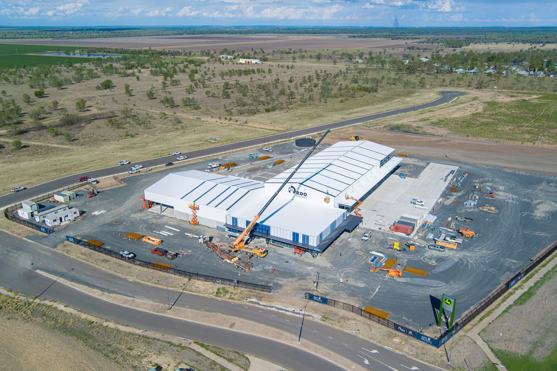 Aerial view of a large white building under construction on a concrete pad with surrounding dirt and landscape — Dynamic Crane Hire In Emerald, QLD
