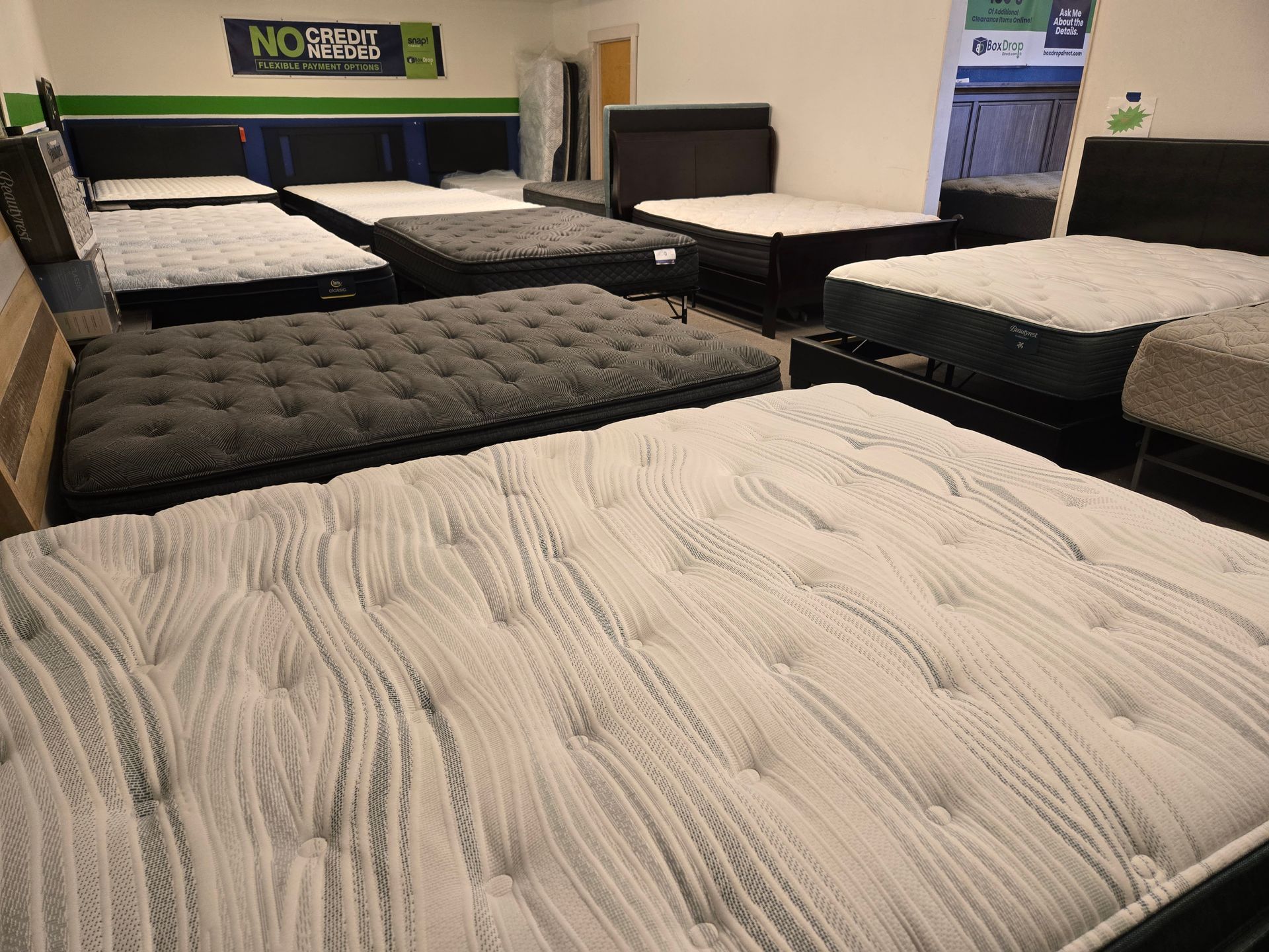 Mattresses and bedroom furniture — Springfield, OR — Northwest Home Furnishings A showroom display filled with several mattresses of various colors and textures on bed frames.