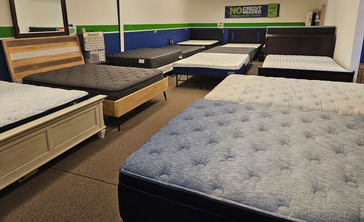 Mattresses — Springfield, OR — Northwest Home Furnishings A showroom filled with various mattresses on bed frames, featuring wood, white, and dark blue furniture styles.
