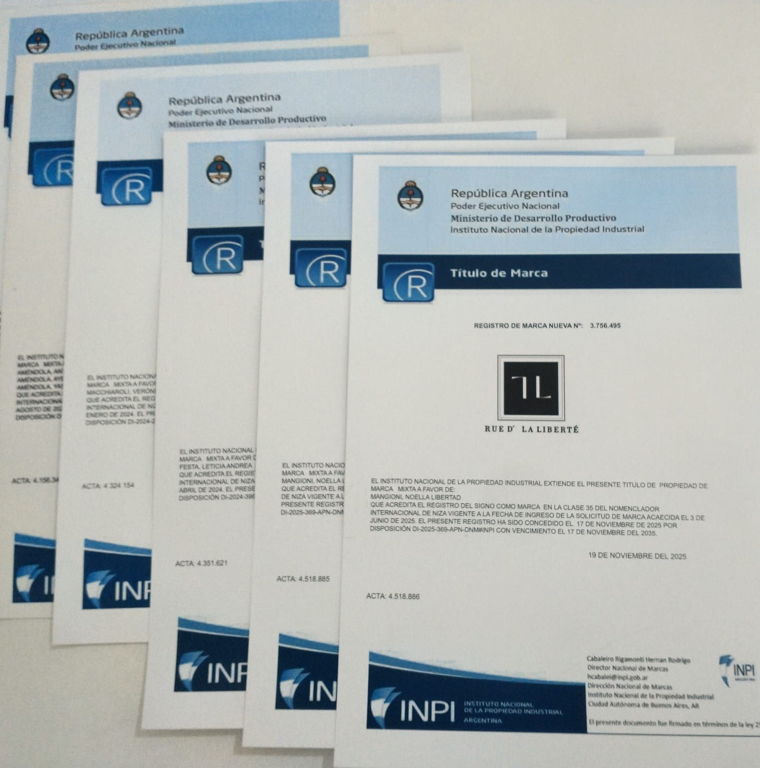 Pila de documentos de patentes francesas con encabezados INPI azules y un logotipo negro sobre una página blanca.