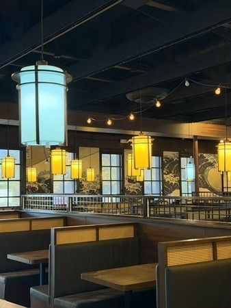 Stylish restaurant interior with glowing pendant lanterns above dark booths and tables