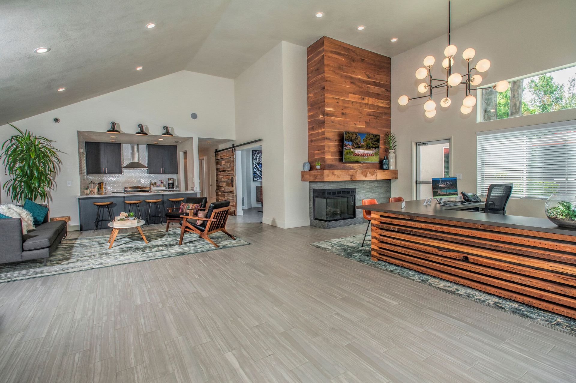 Spacious modern community lobby with reception desk, fireplace, and lounge seating at Shore Park at Riverlake.