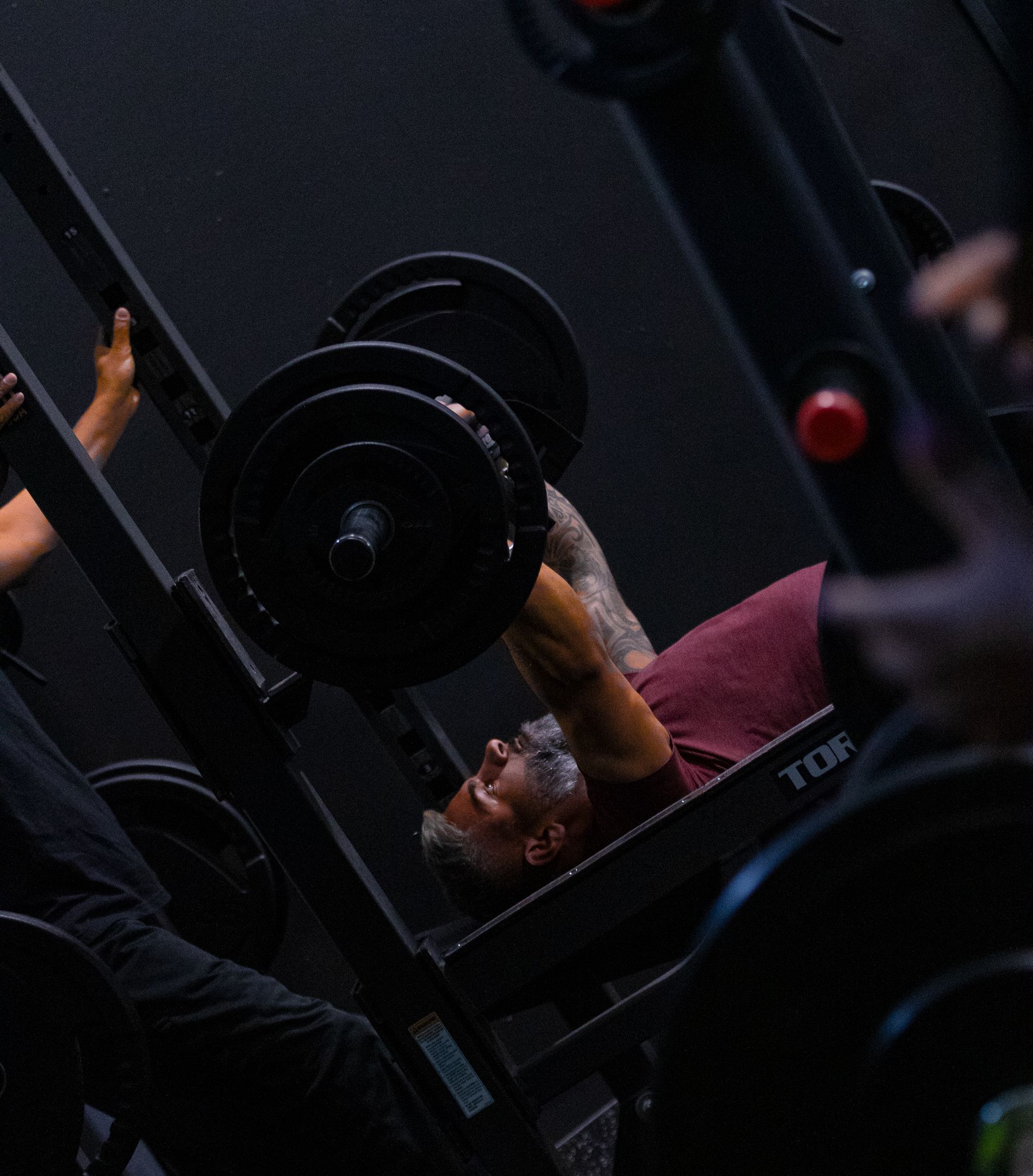 a man is lifting a barbell on a bench