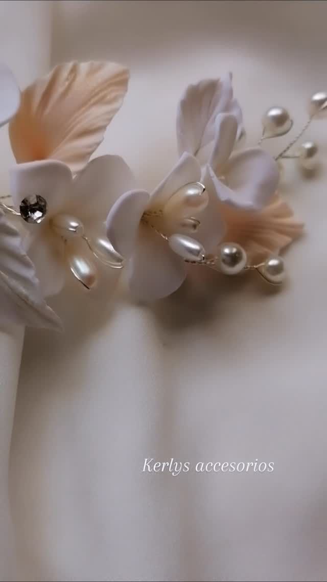 Accesorio floral para el cabello en blanco y beige, con detalles de perlas sobre un fondo suave