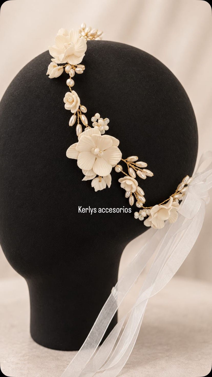 Cabeza de maniquí negra con un tocado floral blanco y detalles de cintas transparentes