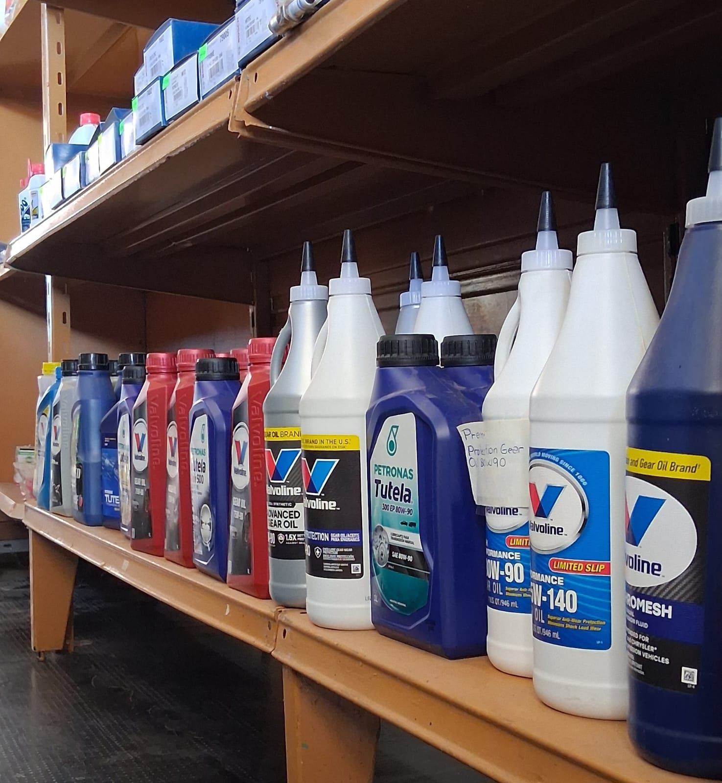 Estanterías con diversos fluidos y lubricantes para automóviles en un pasillo de la tienda.