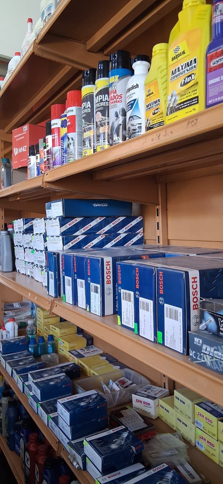 Estantes en un pasillo de una tienda repletos de coloridos fluidos para automóviles y envases de aceite.