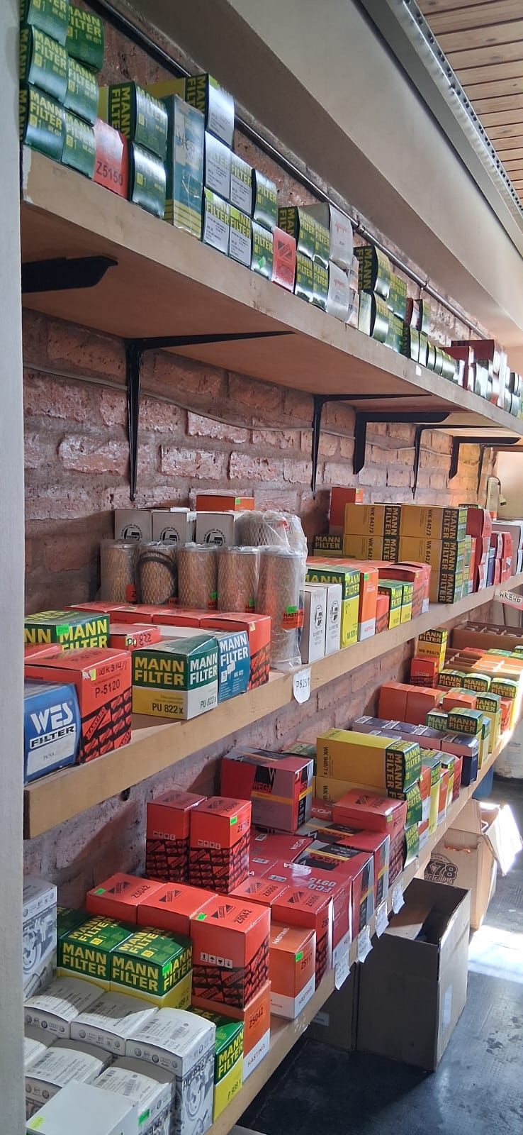 Estantes repletos de coloridos productos envasados en un pequeño pasillo de un supermercado o mercado.