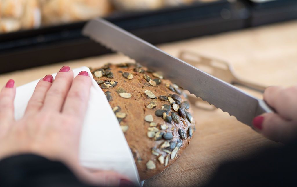 Ein Laib Brot, welches frisch angeschnitten wird.