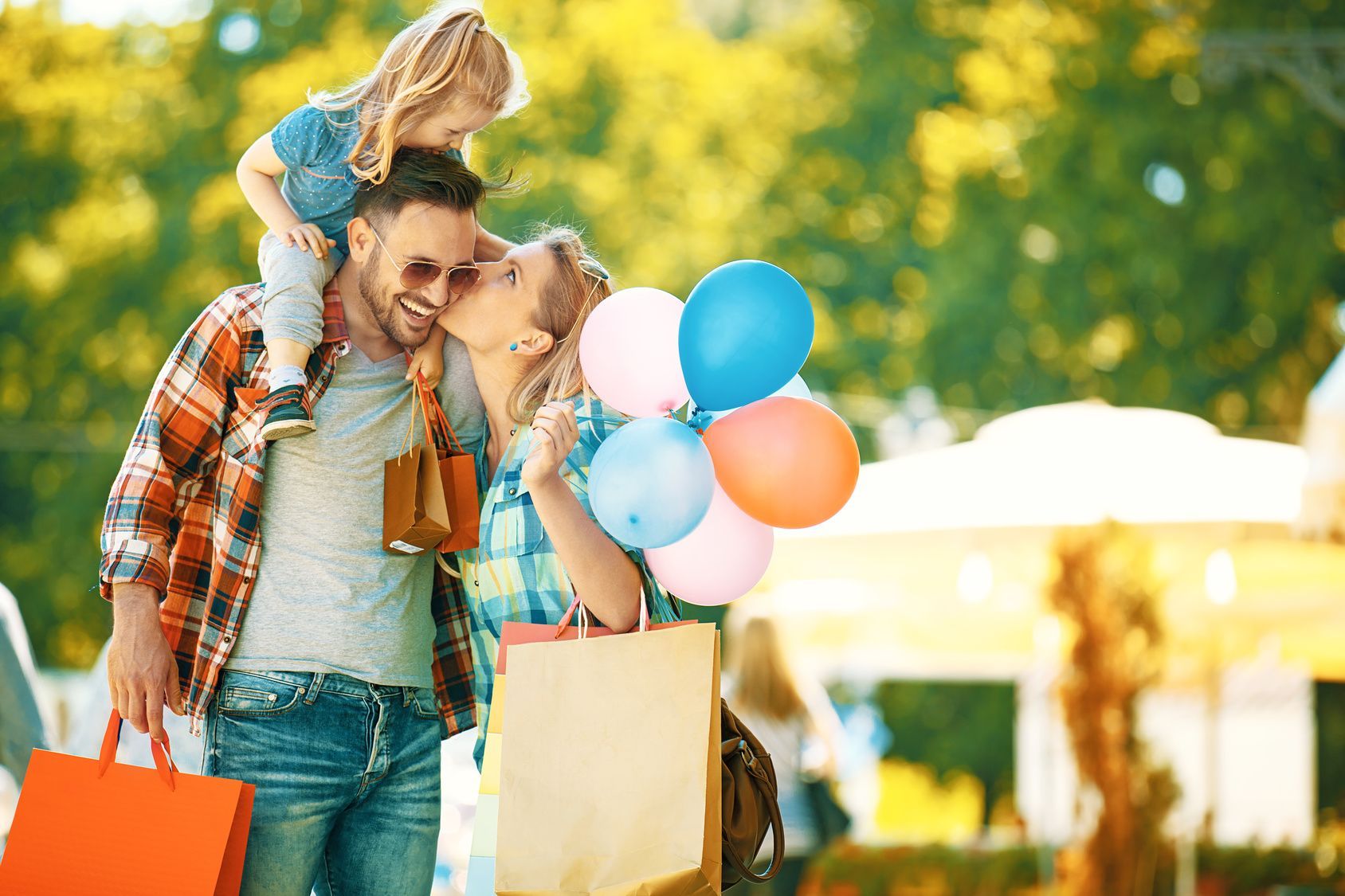 Familie mit Schoppingtüten und Luftballoons