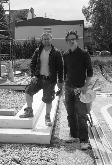 Herr Geisler und Arbeiter bei Bau des Appartmenthauses. Bild in schwarz-weiß.