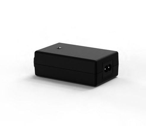A black power supply is sitting on a white surface