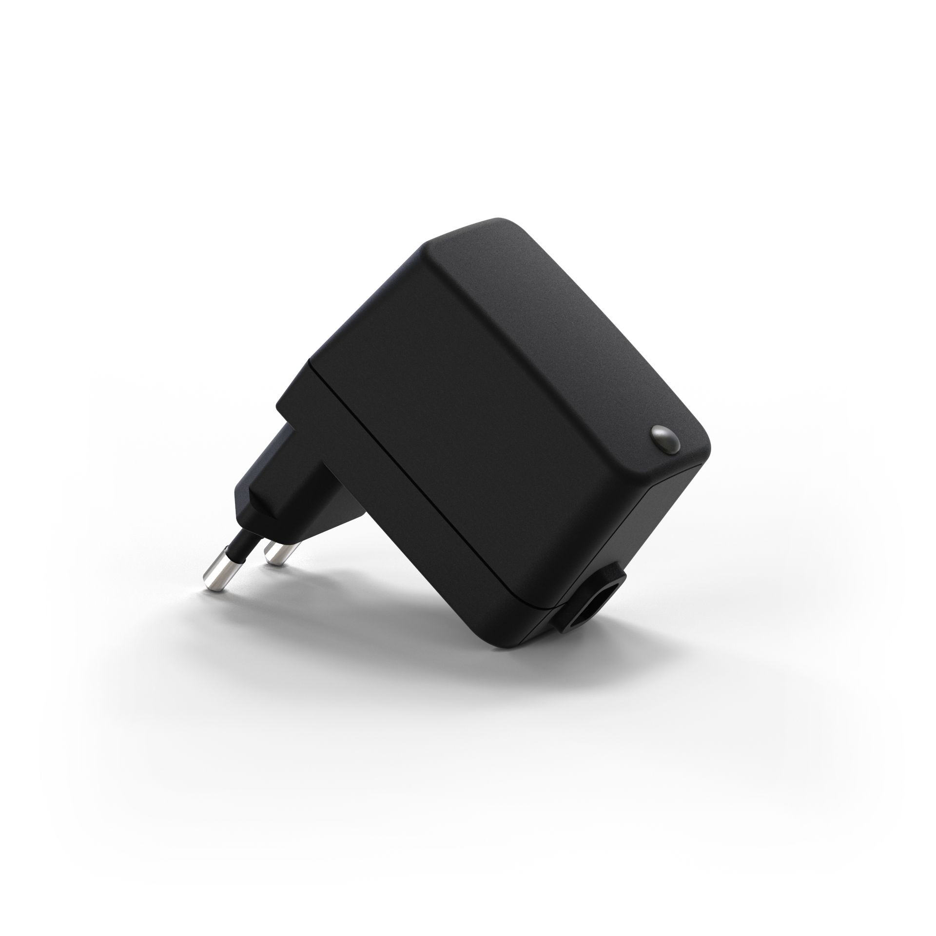 A black power supply is sitting on a white surface