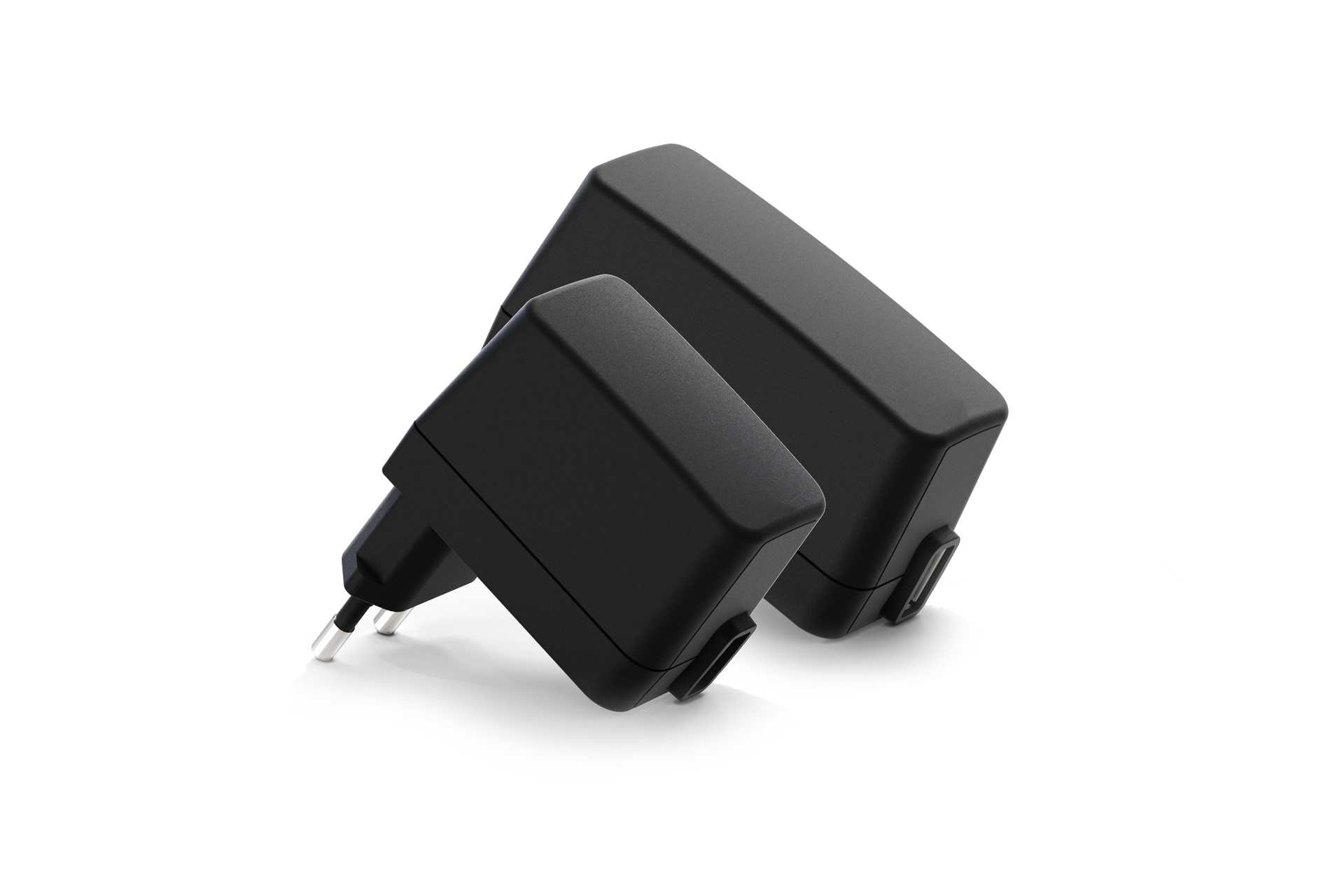 Two black power supplies are sitting on top of each other on a white surface.