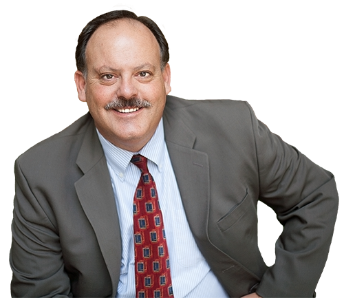 A man in a suit and tie is smiling for the camera