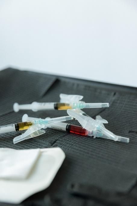 A person is holding a syringe and a bag of liquid.