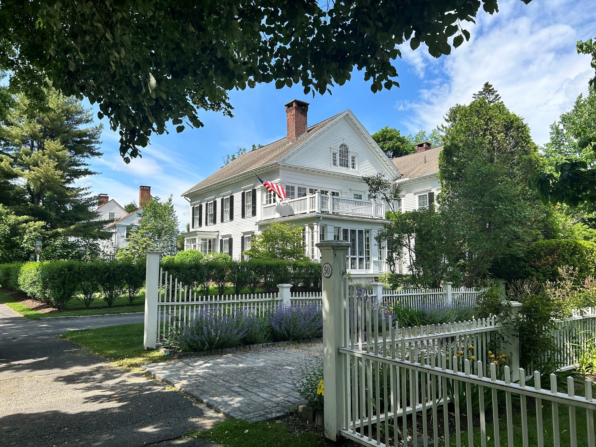 A large white house with a white picket fence in front of it