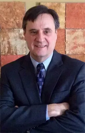 A man in a suit and tie with his arms crossed