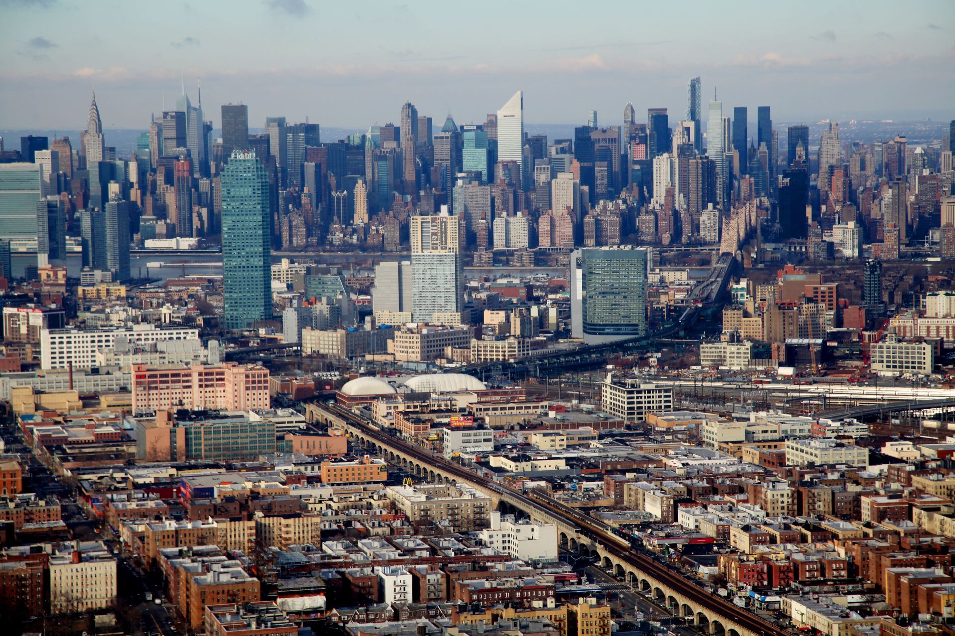 Wide city skyline with dense skyscrapers and rows of buildings under a hazy sky