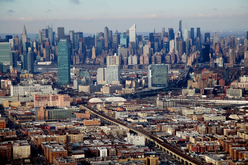 Wide city skyline with dense skyscrapers and rows of buildings under a hazy sky
