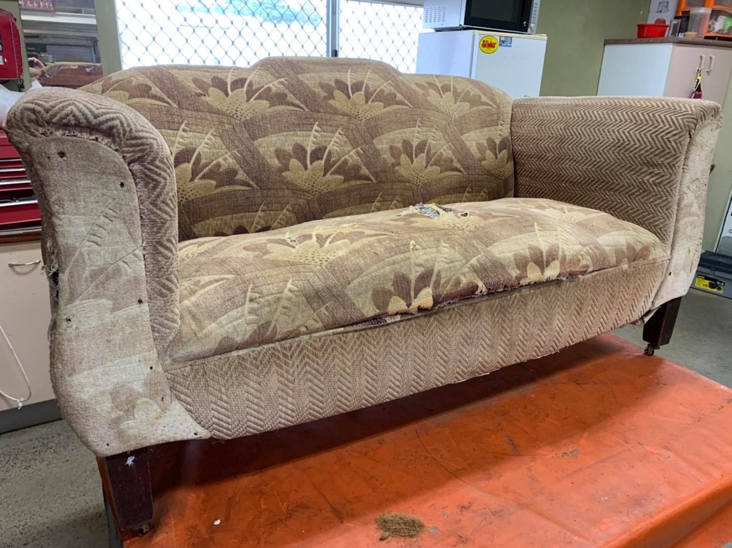 A couch is sitting on top of an orange table in a room — Aztak Upholstery In Manunda, QLD