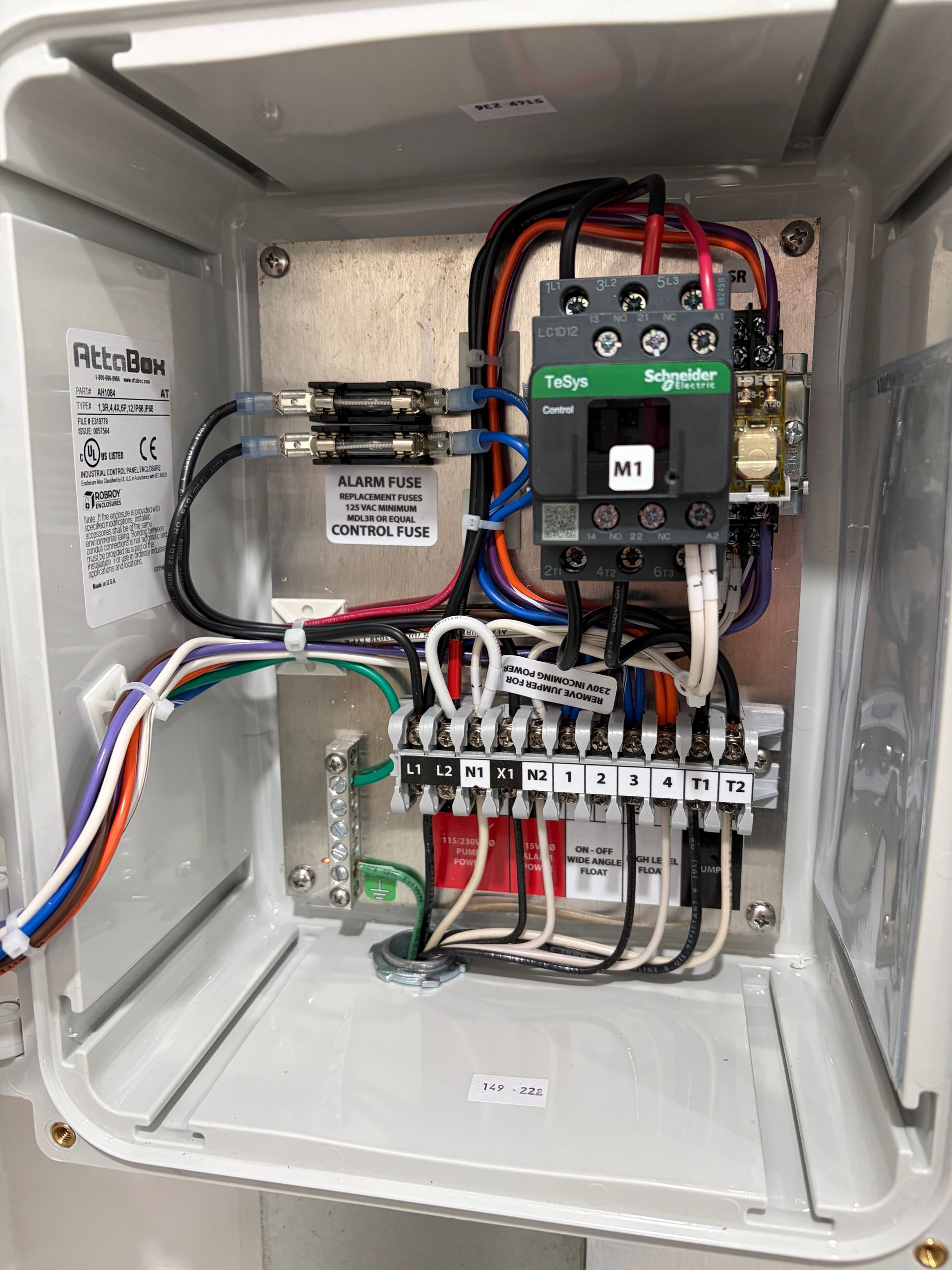 Open electrical control panel with circuit breakers, relays, wiring, and contactor mounted inside a metal enclosure