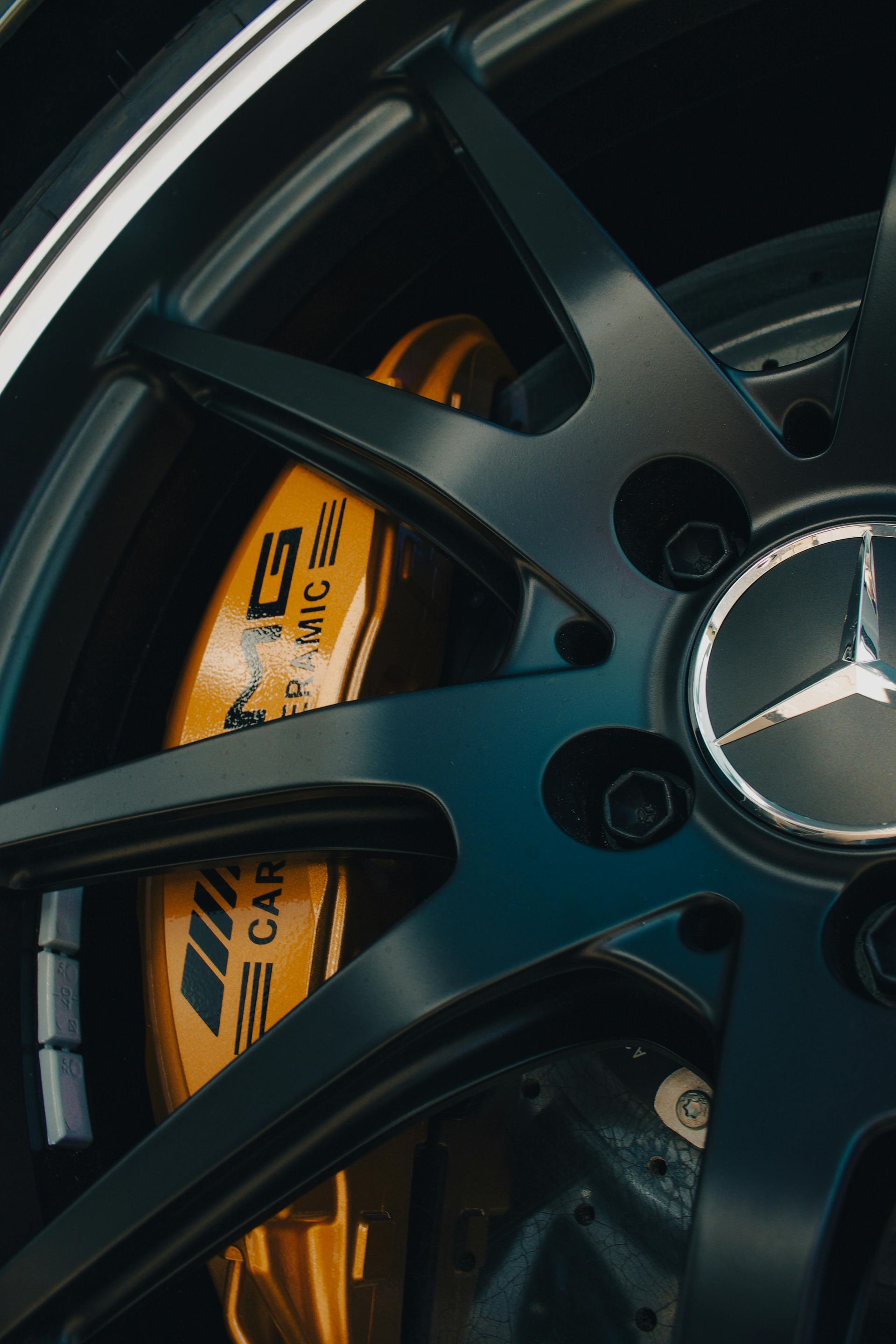 Black Mercedes wheel with gold brake caliper.