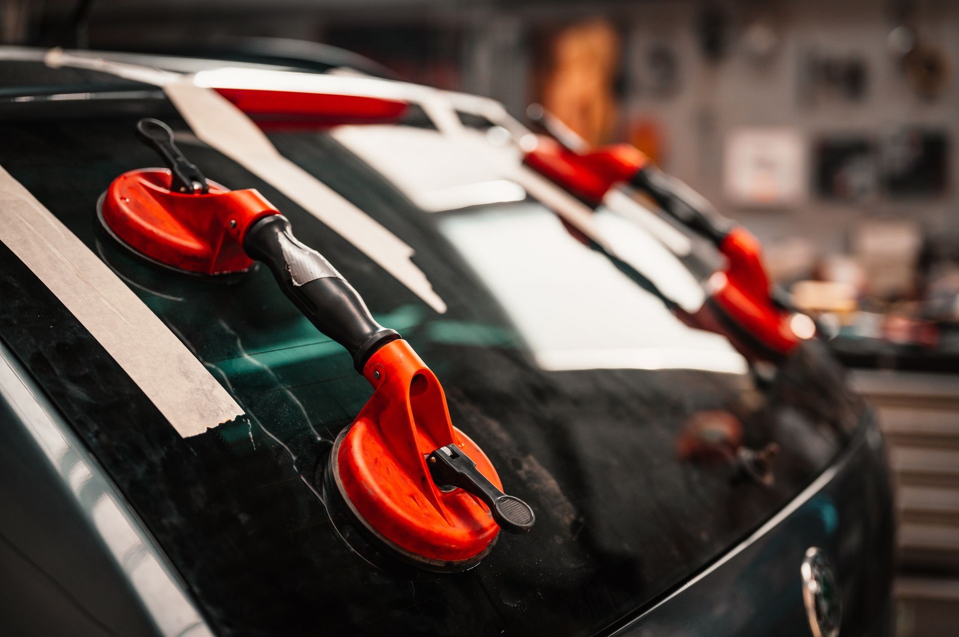 Close-up of orange suction-cup climbing holds attached to a glossy black surface with white stripes