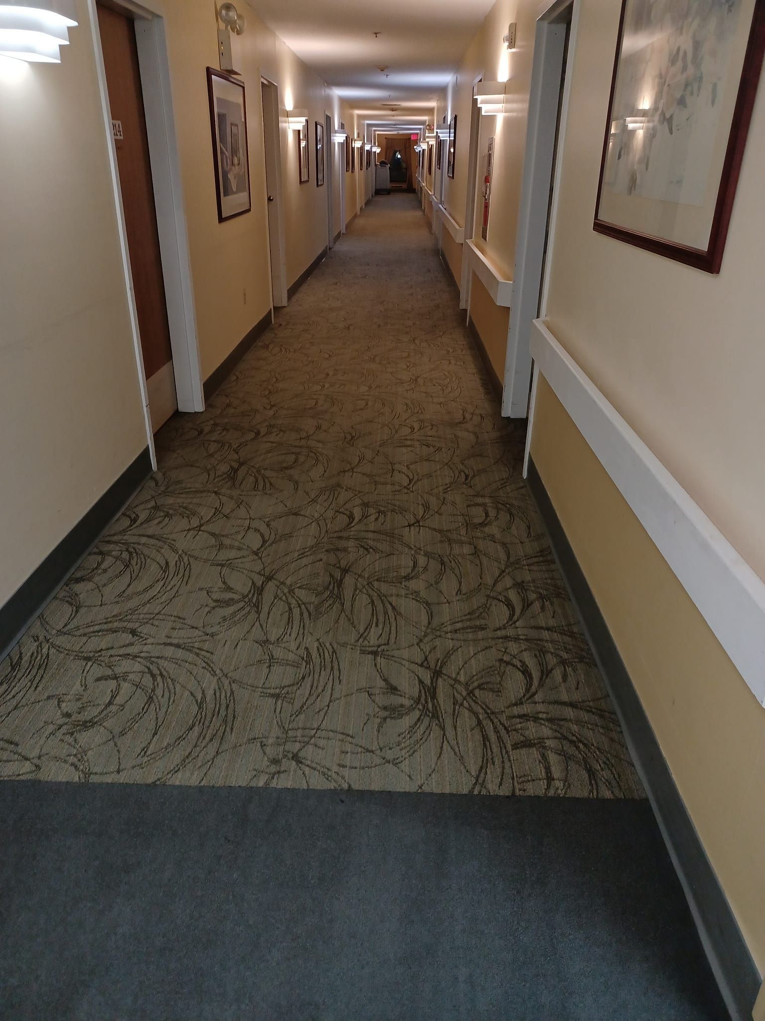 A long hallway in a hotel with a carpeted floor
