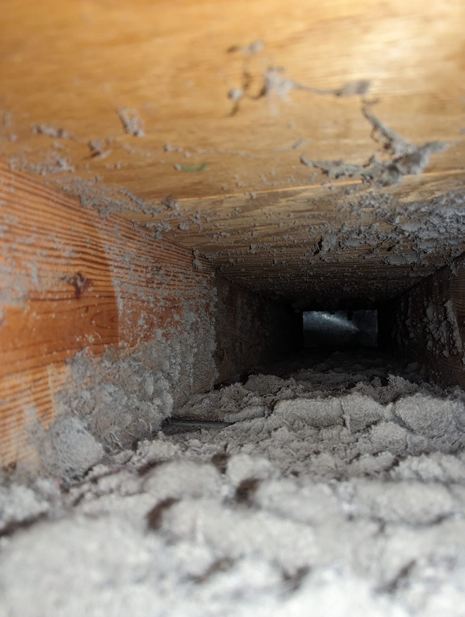 A close up of a dirty air vent in a house.