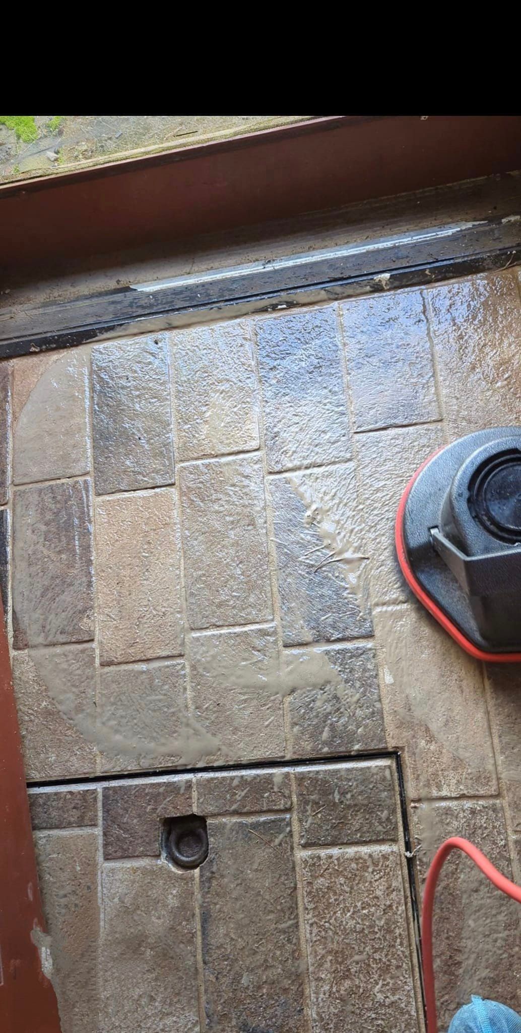 A person is cleaning a tile floor with a machine.