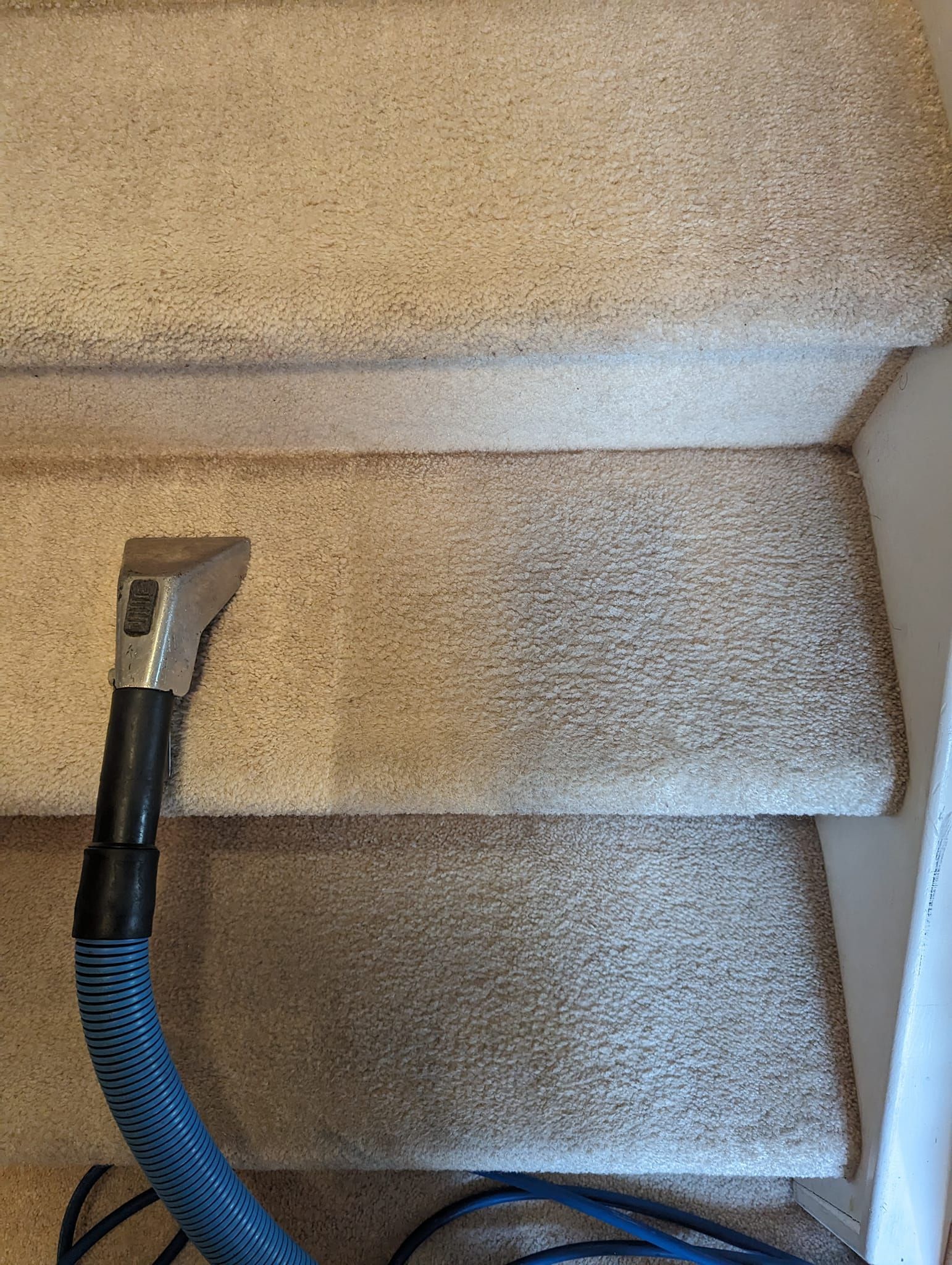 A vacuum cleaner is sitting on top of a set of stairs.