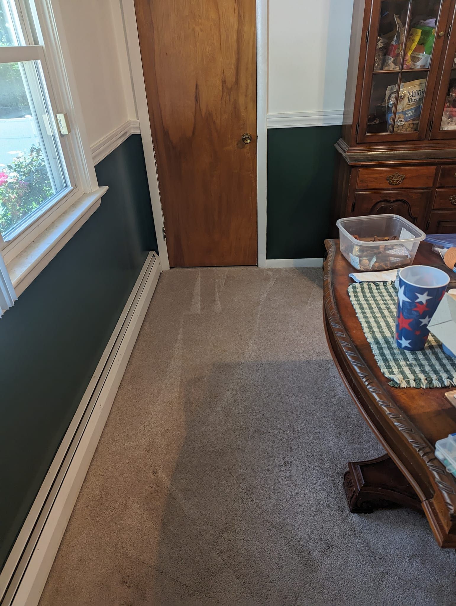 A dining room with a wooden table and a wooden door.