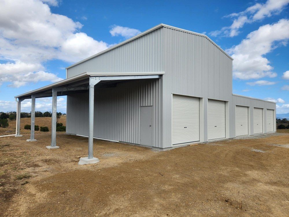 A Large White Metal Building With A Covered Porch — Whit Coast Sheds in  Gregory River, QLD