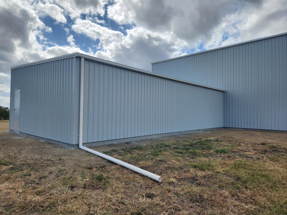 A Large White Building With A White Gutter On The Side Of It — Whit Coast Sheds in  Gregory River, QLD