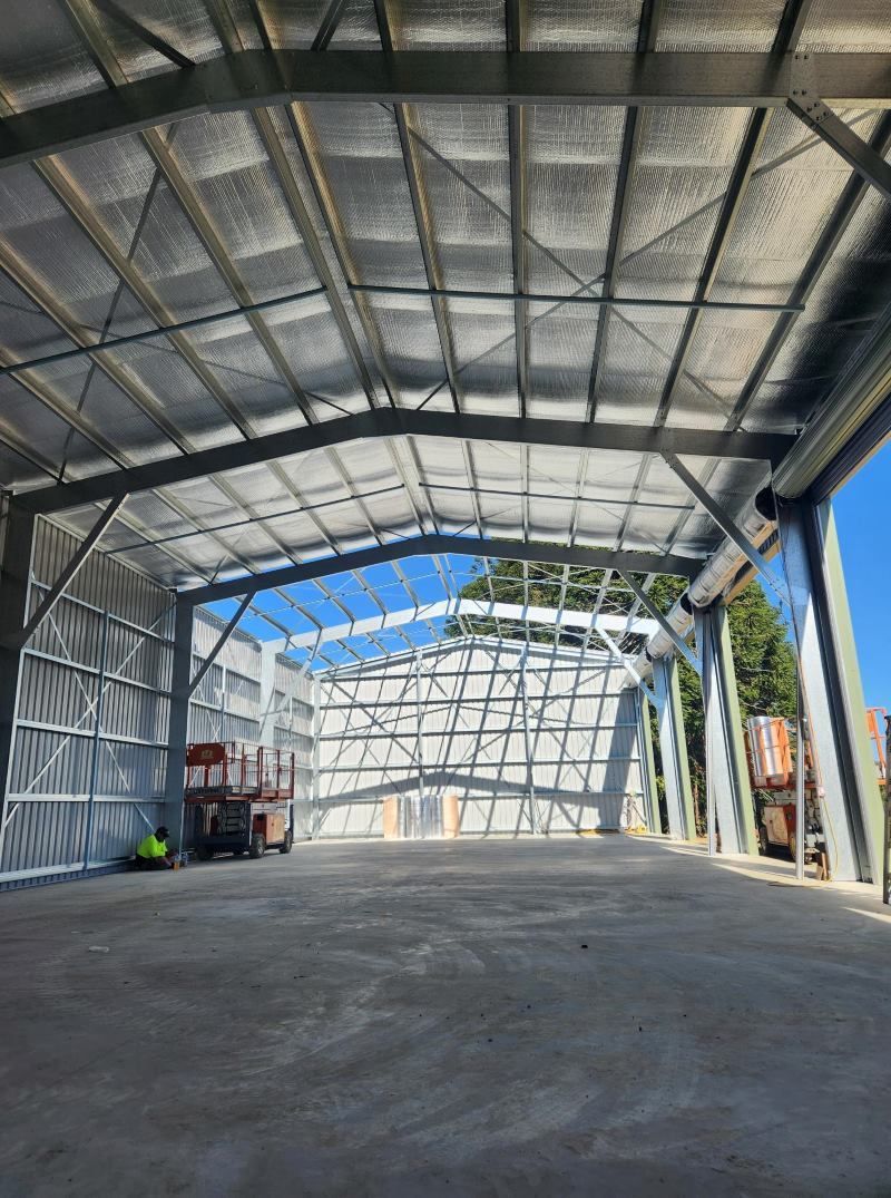 A Large Warehouse With A Lot Of Windows And A Concrete Floor — Whit Coast Sheds in  Gregory River, QLD