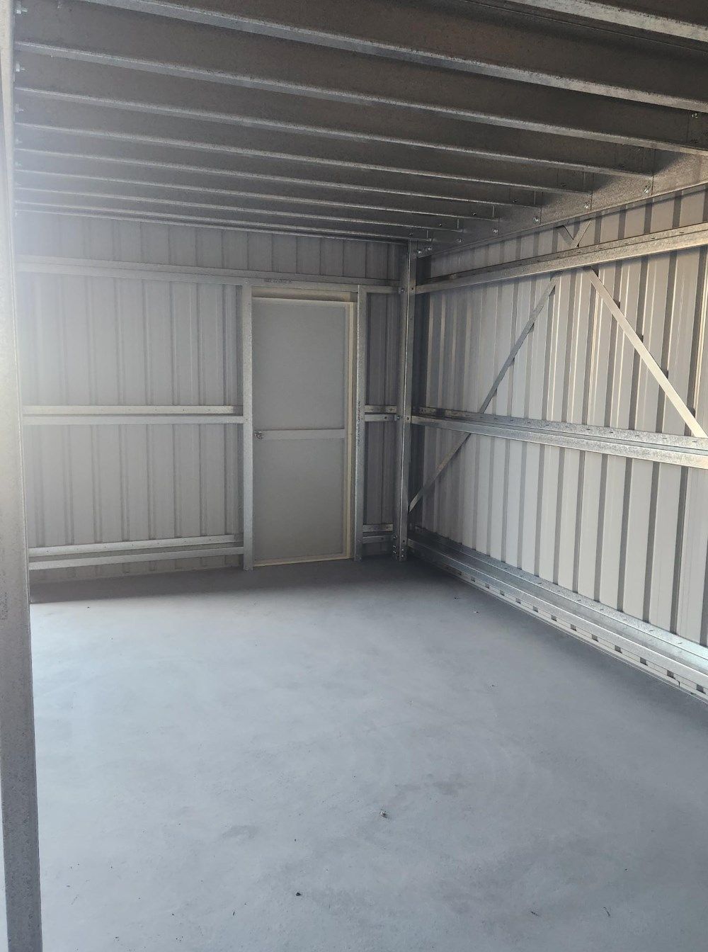 An Empty Garage With A Door And A Ceiling — Whit Coast Sheds in  Gregory River, QLD