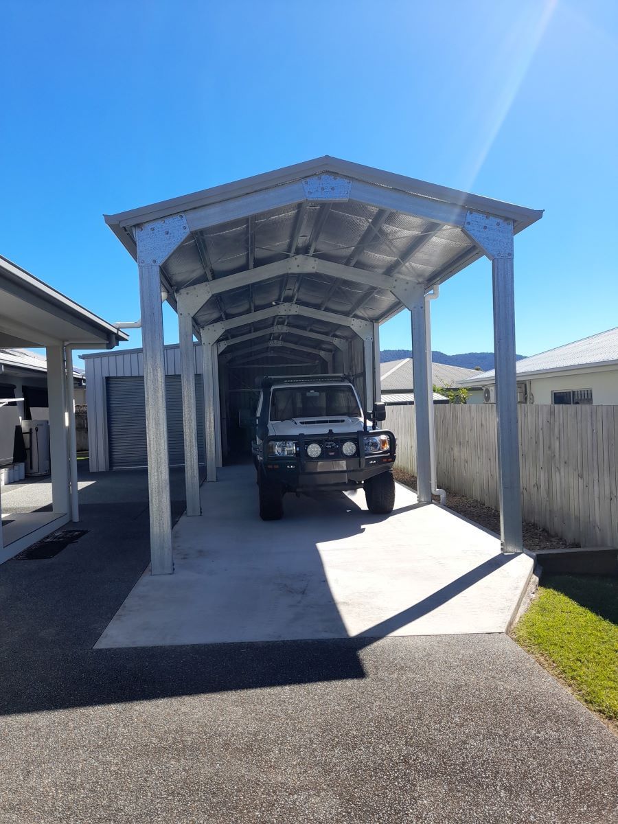 A Car Is Parked Under A Carport In A Driveway — Whit Coast Sheds in Bowen, QLD