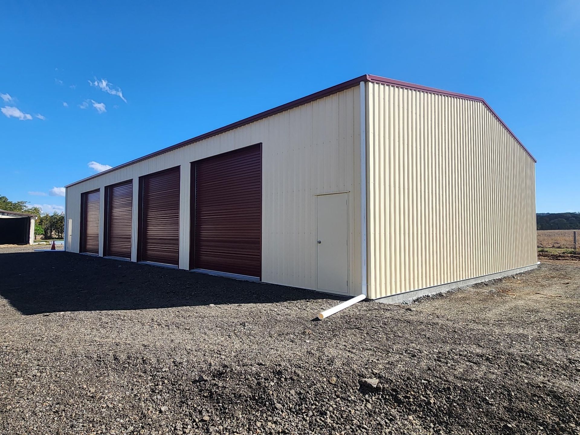 A Black Metal Garage With a Concrete Floor and a Canopy — Whit Coast Sheds in  Gregory River, QLD