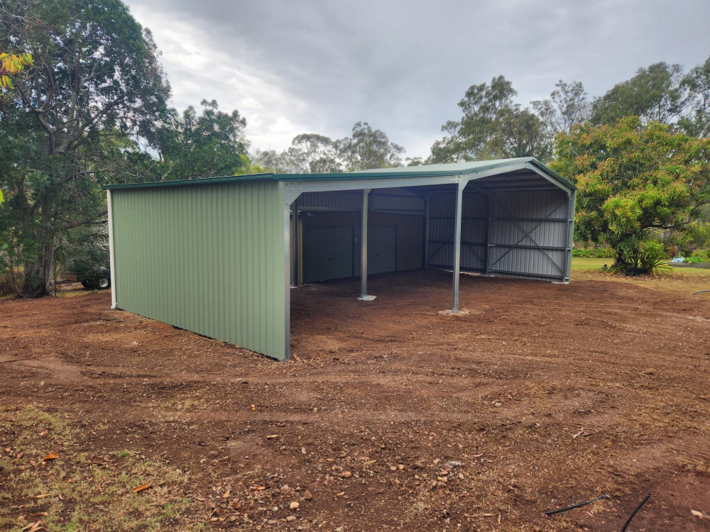 Green metal shed in a grassy outdoor setting— Whit Coast Sheds in Gregory River, QLD
