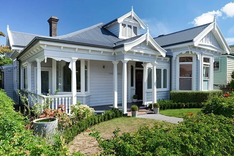 A White House with a Porch and a Blue Roof — Auckland, NZ — Pro Roofing