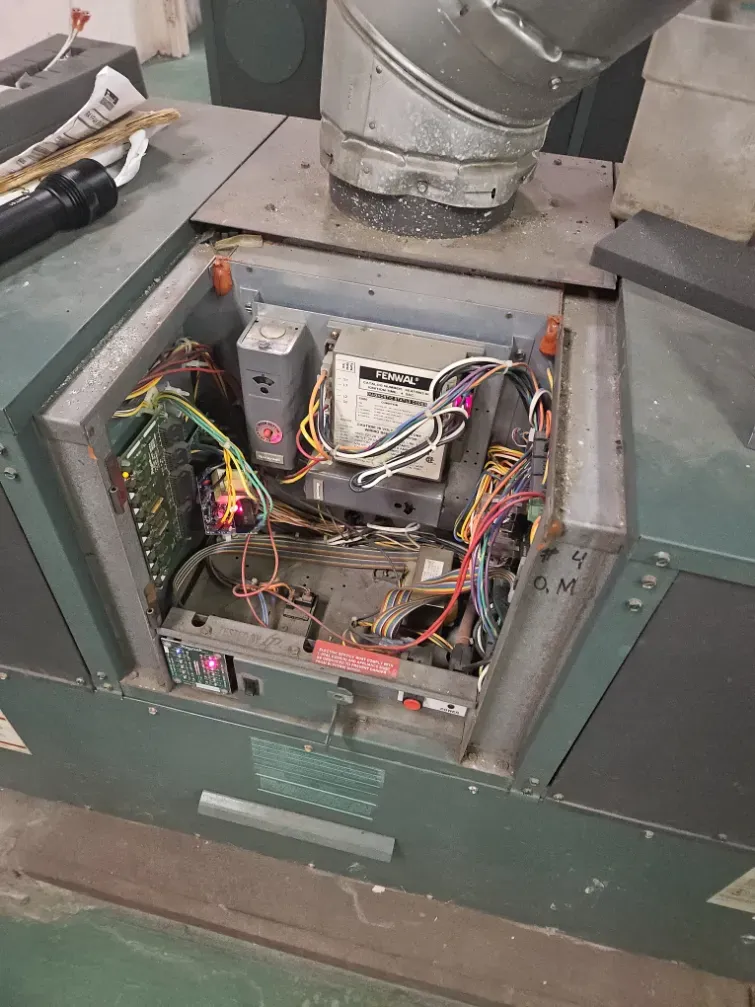 Open machine cabinet with exposed wiring and electronics in a green industrial unit