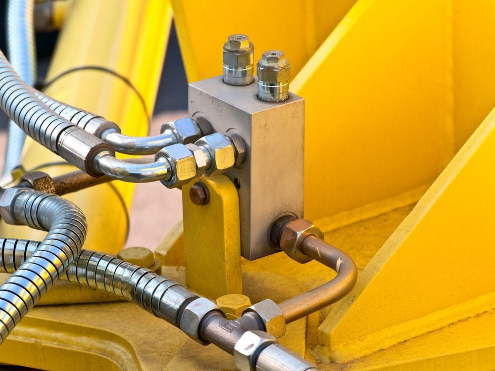 A Metal Hydraulic Manifold Block With Connected Metal Pipes — Action Hose & Fitting Solutions In Gold Coast, QLD