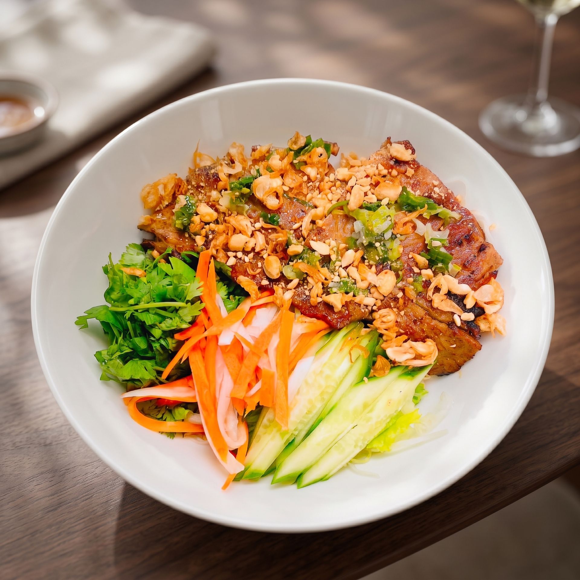 Bowl of rice with seasoned meat, greens, cucumber, carrot, and herbs on a wooden table