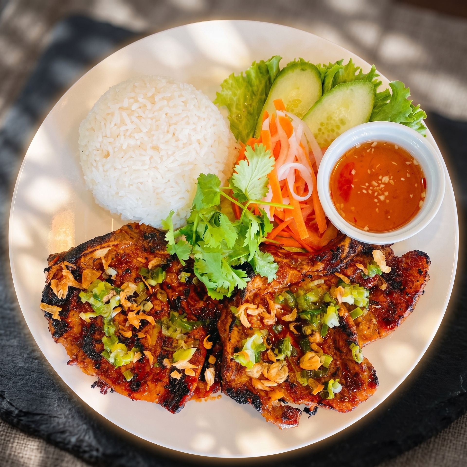 Grilled chicken with rice, salad, and dipping sauce on a plate with lettuce garnish