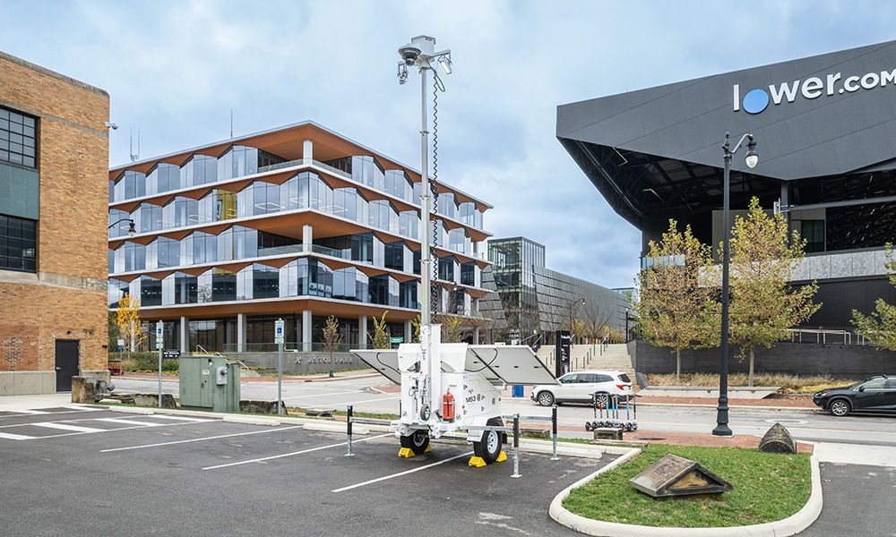 Mobile tower in a parking lot, near modern buildings with glass windows and a