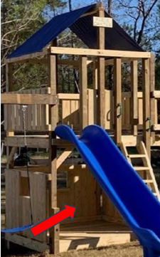 Wooden playground structure with blue slide and red arrow pointing to lower deck area